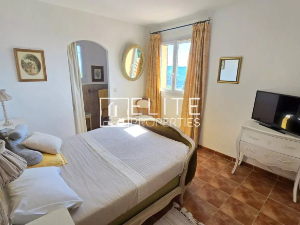 Chambre d'une maison à Tanneron avec lit, télévision et vue sur la mer.