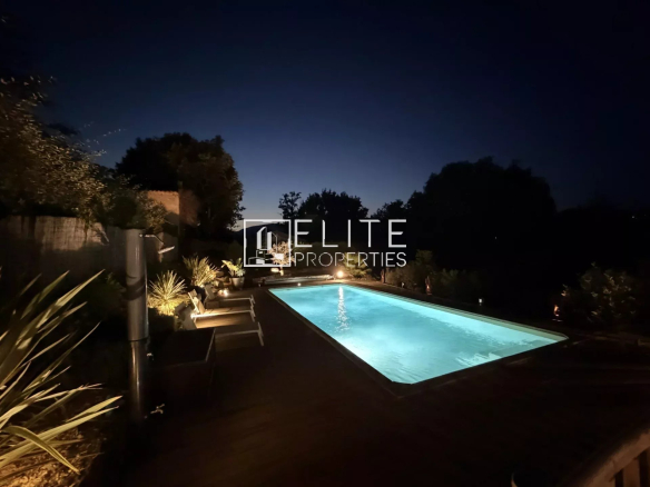 Swimming pool lit at night in a villa in Fayence with green spaces around it.
