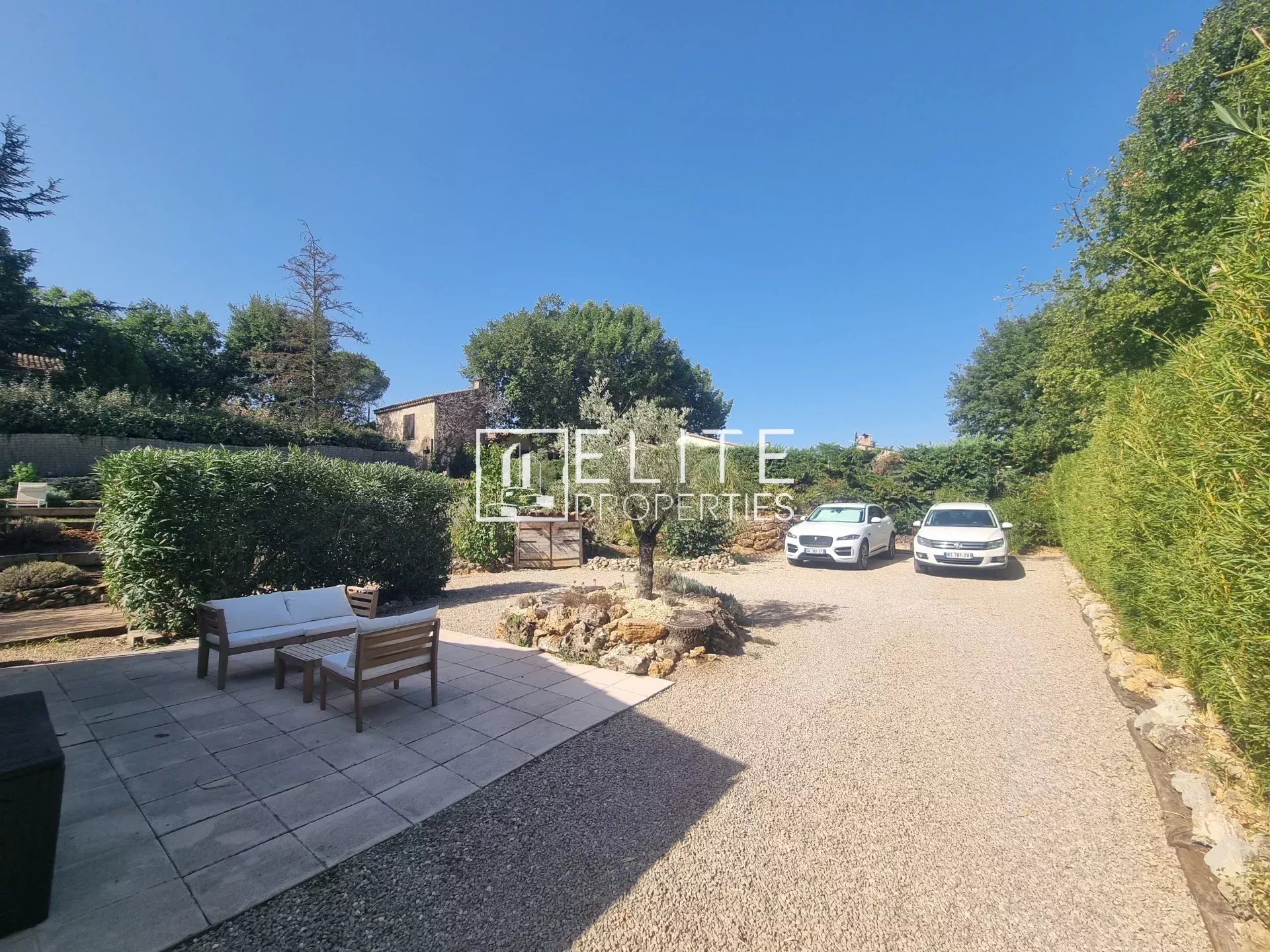 Villa in Fayence with garden and cars View of a villa with garden and two cars parked in Fayence.