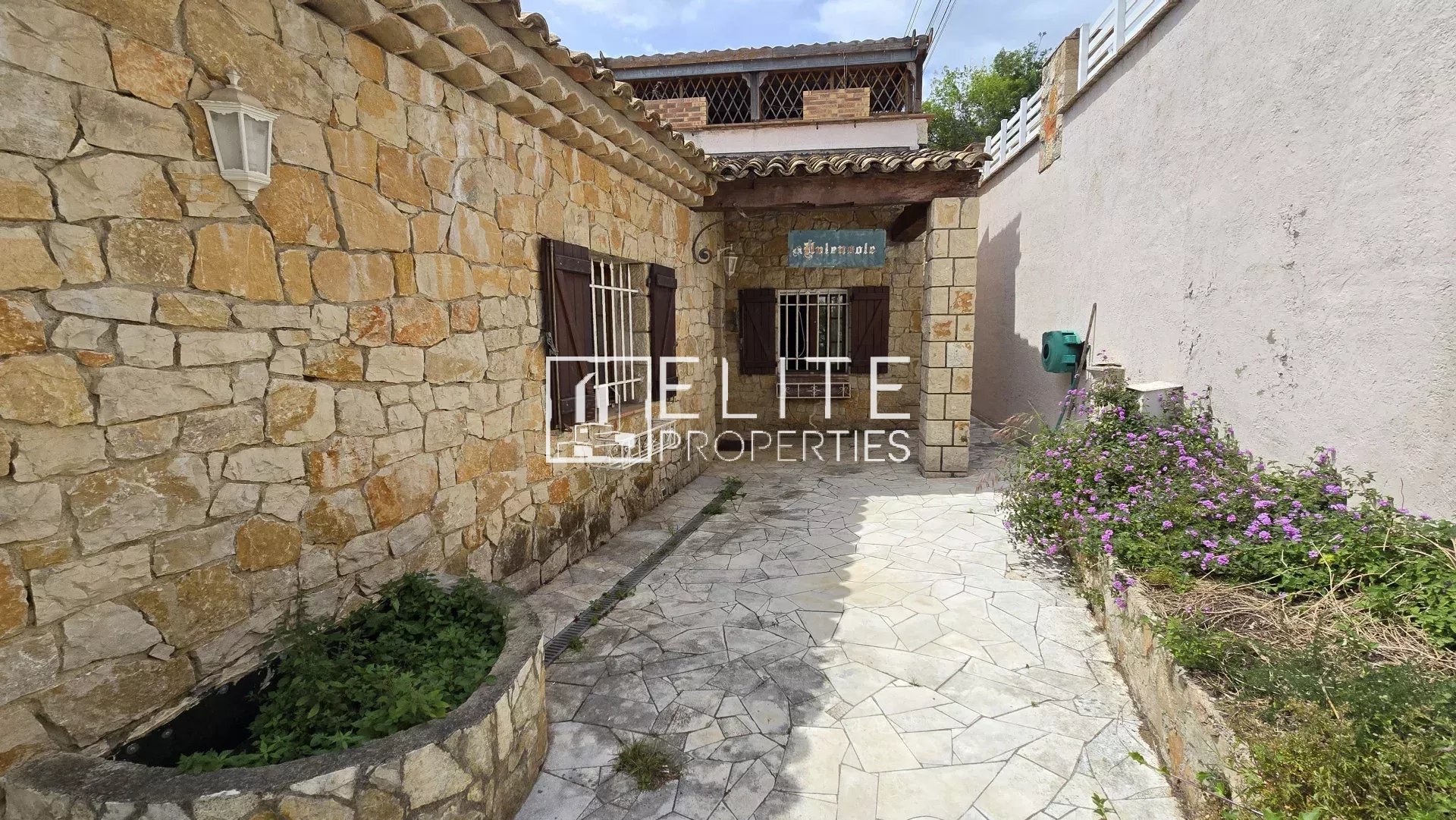 Entrée d’une maison à Mandelieu-la-Napoule Entrée d'une maison en pierre avec un espace extérieur fleuri à Mandelieu-la-Napoule.