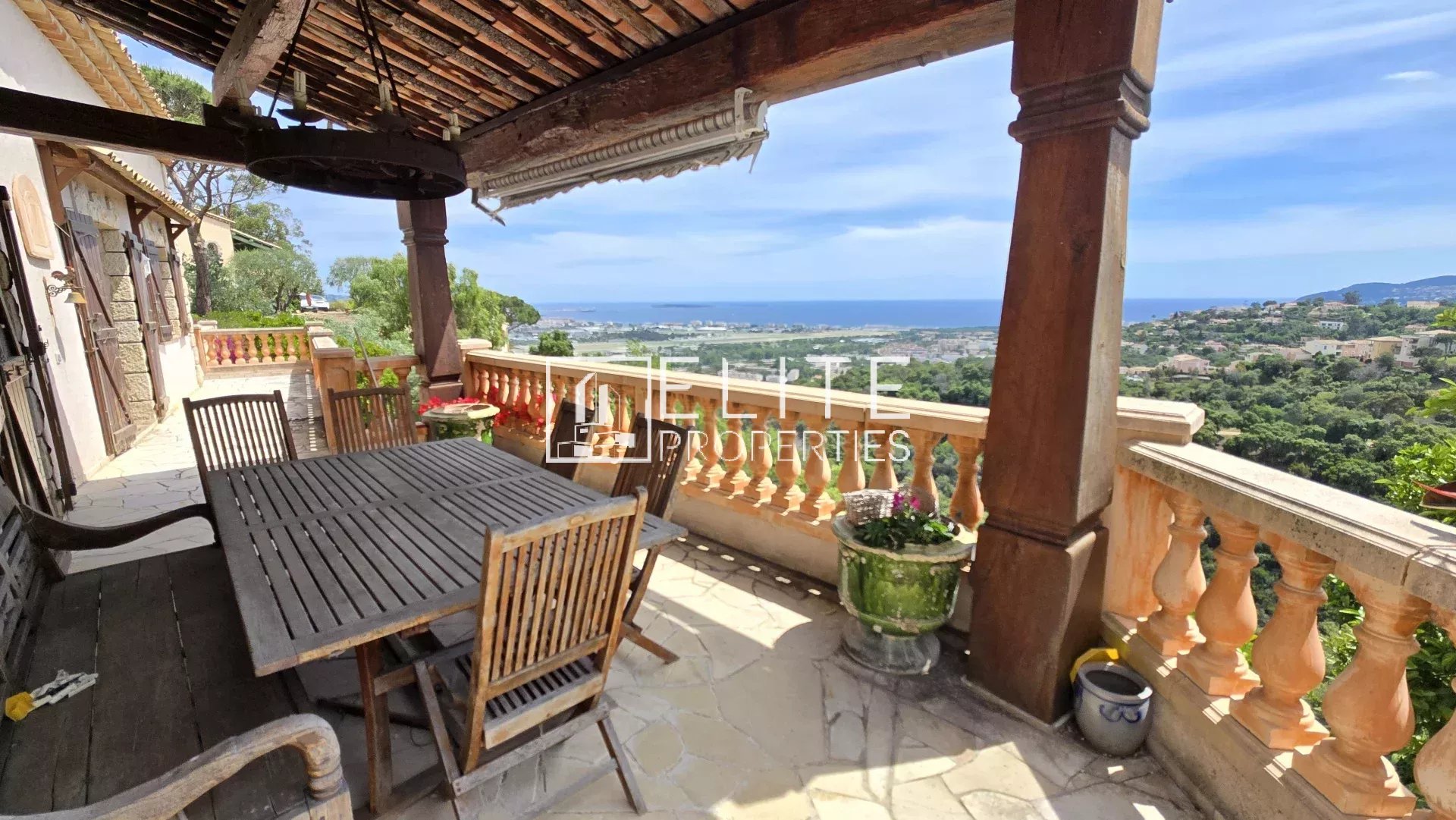 Terrasse avec vue panoramique à Mandelieu-la-Napoule Terrasse d'une maison avec vue sur la mer et îles de Lérins, mobilier en bois, environnement calme.