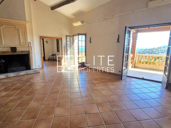 Interior of a spacious house with fireplace and large windows offering panoramic views.