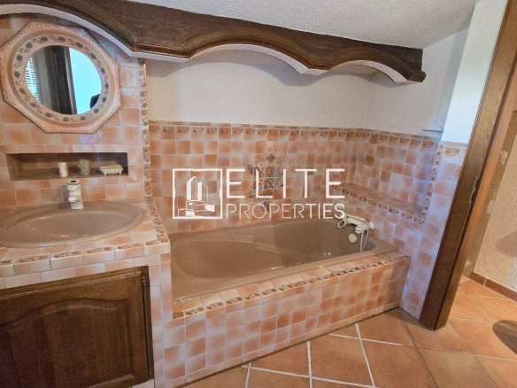 Bathroom with tiled bath and sink in a house in Mandelieu-la-Napoule.