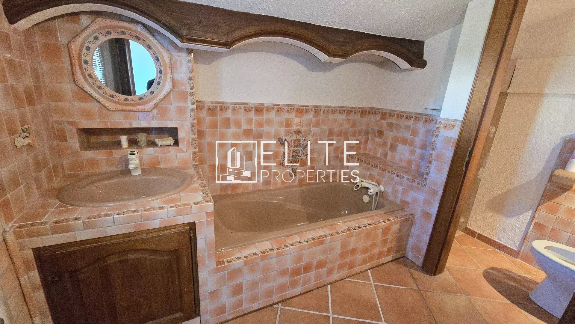 Bathroom in a house in Mandelieu-la-Napoule Bathroom with tiled bath and sink in a house in Mandelieu-la-Napoule.