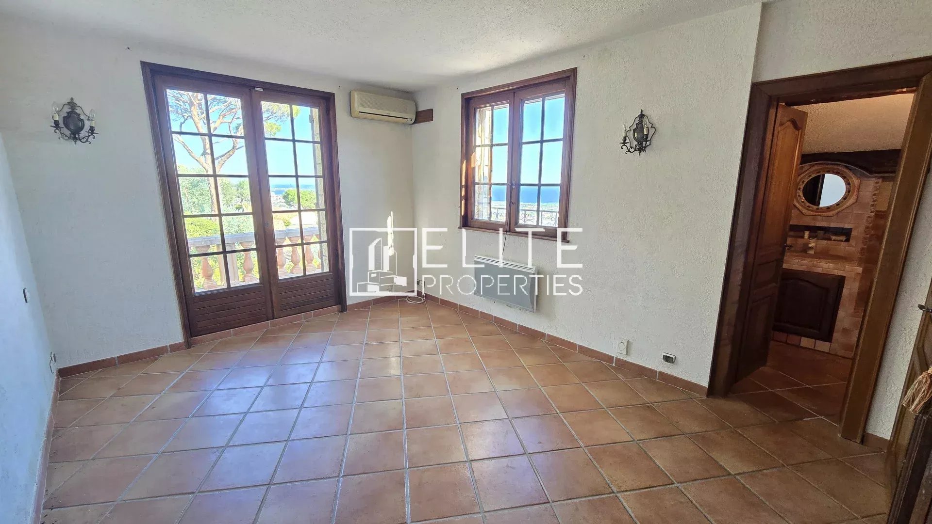 Interior of a house in Mandelieu-la-Napoule Interior of a house with windows overlooking the sea, tiled floor and light-colored walls.