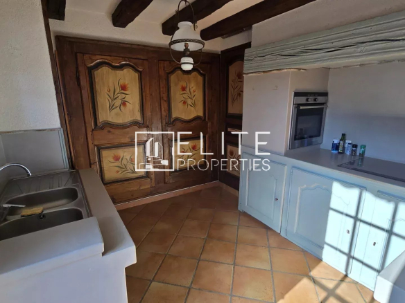 Kitchen of a 155 m² house in Mandelieu-la-Napoule, with wooden elements and tiled floor.