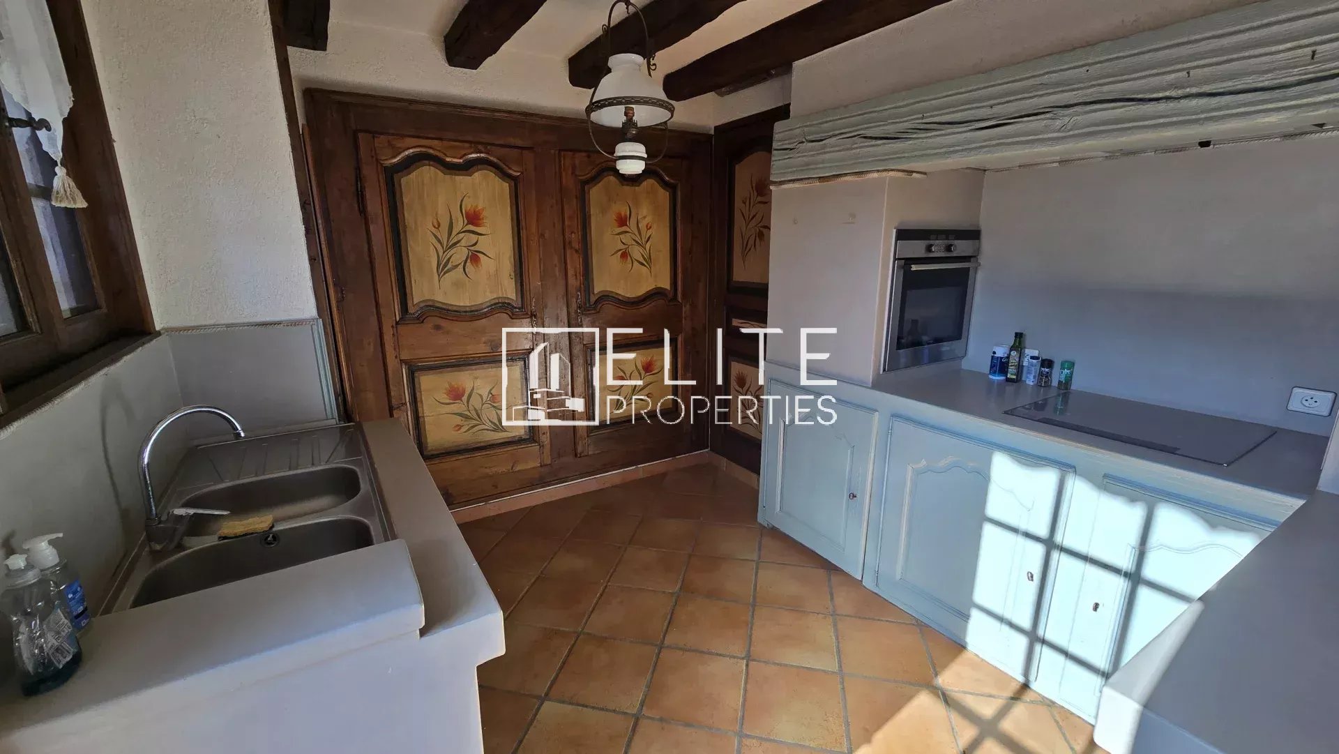 Home cooking in Mandelieu-la-Napoule Kitchen of a 155 m² house in Mandelieu-la-Napoule, with wooden elements and tiled floor.