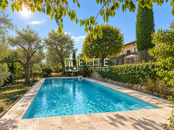 Piscine entourée d'arbres et de verdure dans une propriété à Grasse.