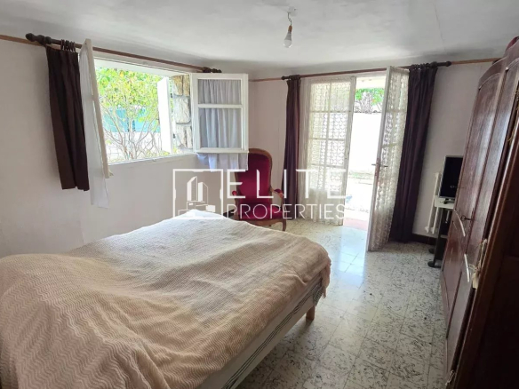 Chambre d'un appartement avec lit, armoire et accès à un espace extérieur.