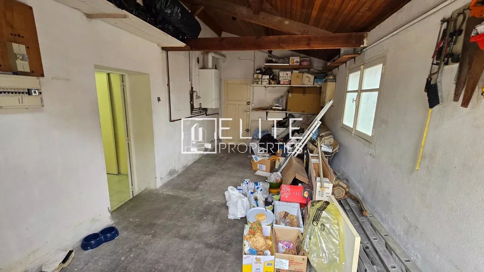 Garage à Juan-les-Pins Intérieur d'un garage en désordre avec divers objets et matériel de rangement.