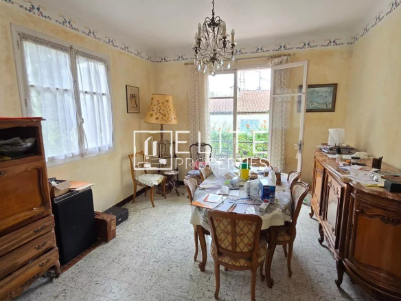 Intérieur d'une maison avec une salle à manger et des meubles anciens.