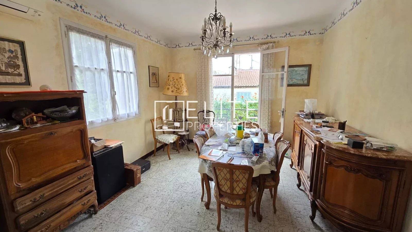 Salle à manger d’une maison à Juan-les-Pins Intérieur d'une maison avec une salle à manger et des meubles anciens.