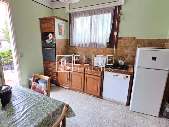 Cuisine d'un appartement 3 pièces avec meubles en bois et appareils électroménagers.