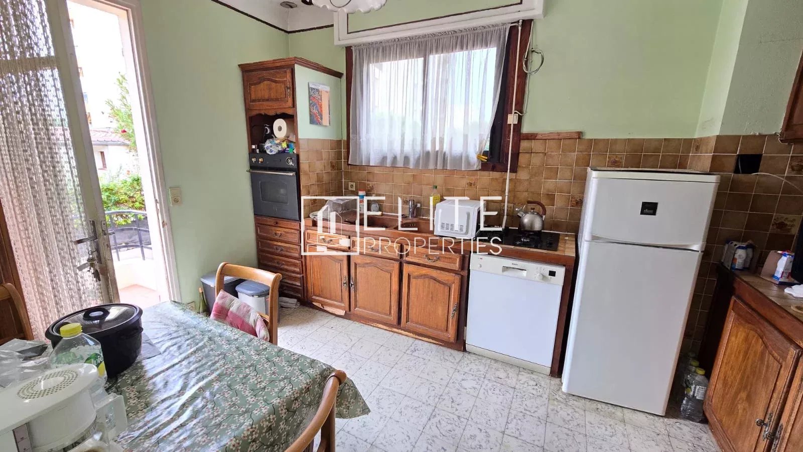 Cuisine d’un appartement à Juan-les-Pins Cuisine d'un appartement 3 pièces avec meubles en bois et appareils électroménagers.