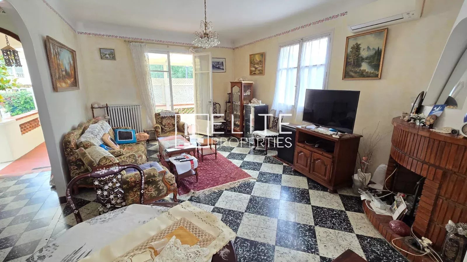 Salon d’une maison à Juan-les-Pins Intérieur d'une maison avec salon et cheminée, mobilier classique et décoration vintage.