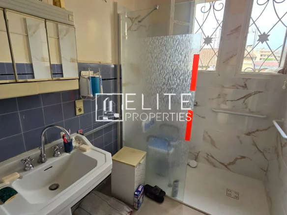 Salle de bain avec douche et lavabo dans un appartement à Juan-les-Pins.