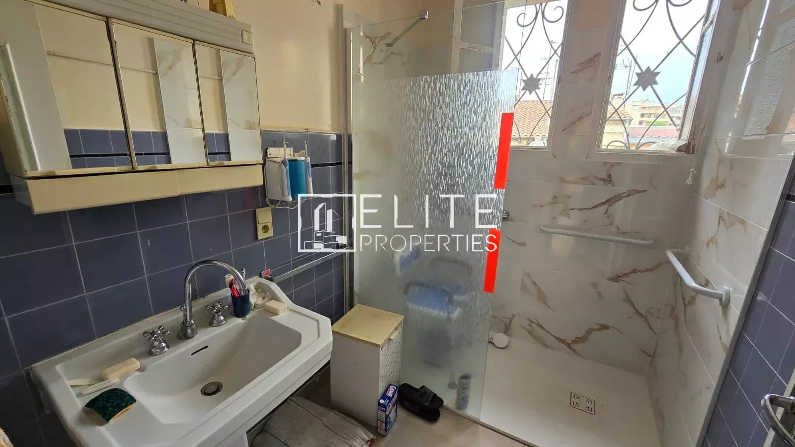 Salle de bain d’un appartement à Juan-les-Pins Salle de bain avec douche et lavabo dans un appartement à Juan-les-Pins.