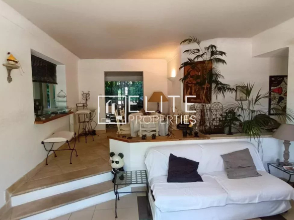 Intérieur d'une maison de plain-pied à Mougins, avec un salon lumineux et des plantes.