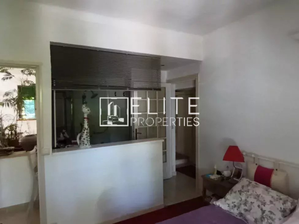 Intérieur d'une maison de plain-pied à rénover avec des murs clairs et des plantes d'intérieur.