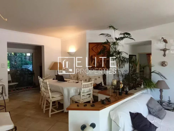 Intérieur d'une maison de plain-pied à Mougins, salon lumineux avec mobilier et plantes.