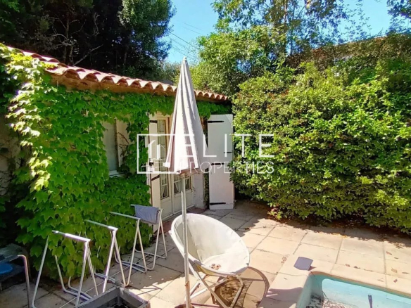 Maison de plain-pied avec jardin arboré à Mougins, vue sur la terrasse et la piscine.