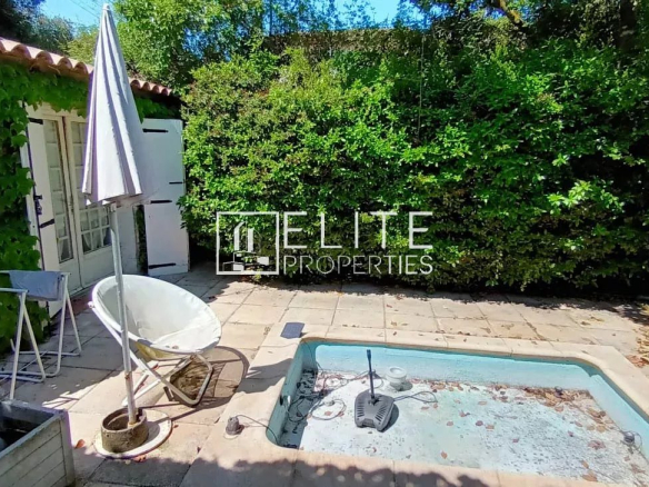 Terrasse d'une maison de plain-pied à rénover, avec une petite piscine et des plantes verdoyantes.