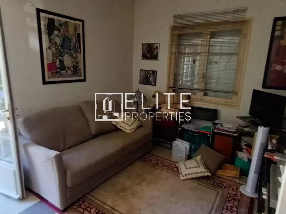 Intérieur d'une maison de plain-pied à rénover, avec un salon et des meubles simples.