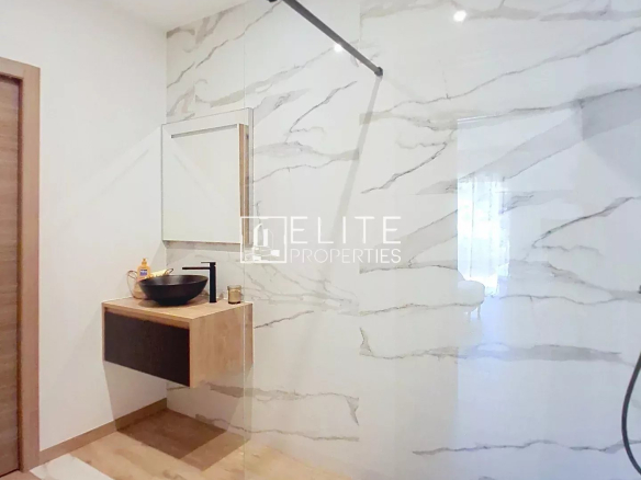 Modern bathroom with walk-in shower and wooden vanity.