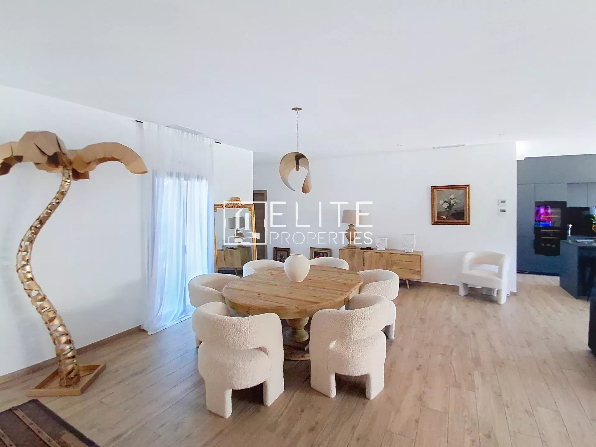 Renovated villa dining room Modern dining room with wooden table and white chairs in a renovated villa in Vallauris.