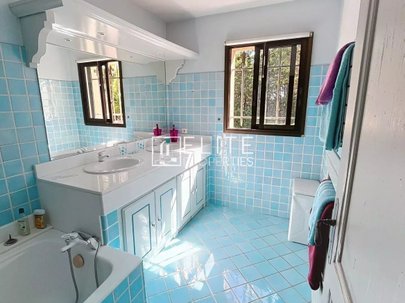 Spacious bathroom with blue tiles and bathtub