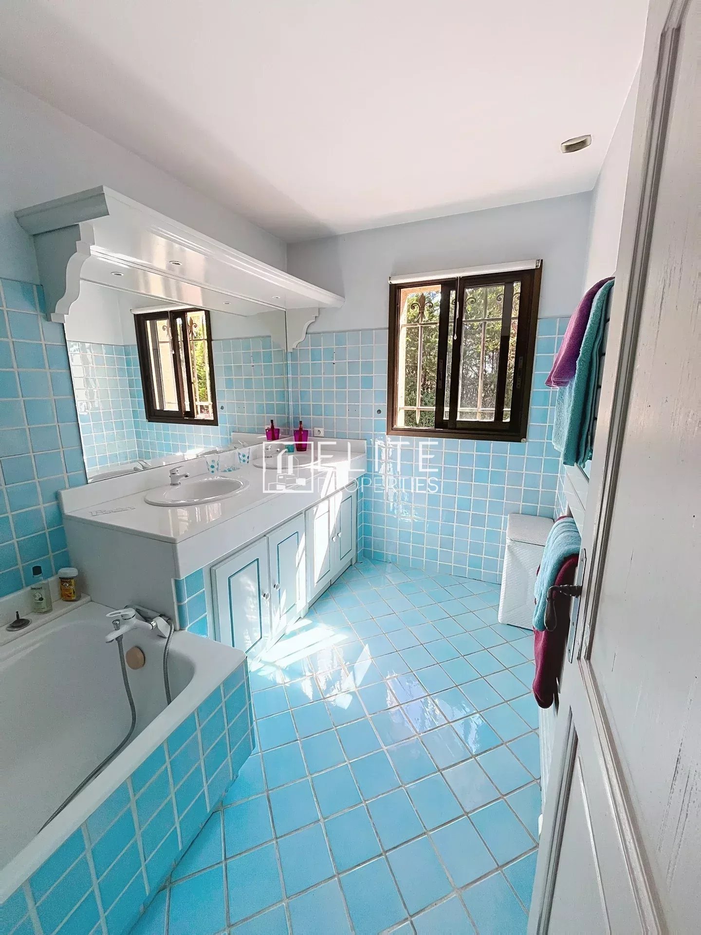 Bathroom of a villa in Mouans-Sartoux Spacious bathroom with blue tiles and bathtub