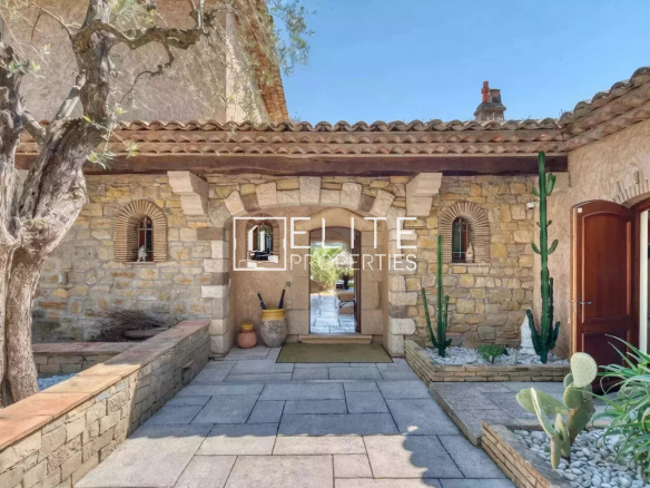 Entrance to a stone villa with garden and olive trees in Mouans-Sartoux.