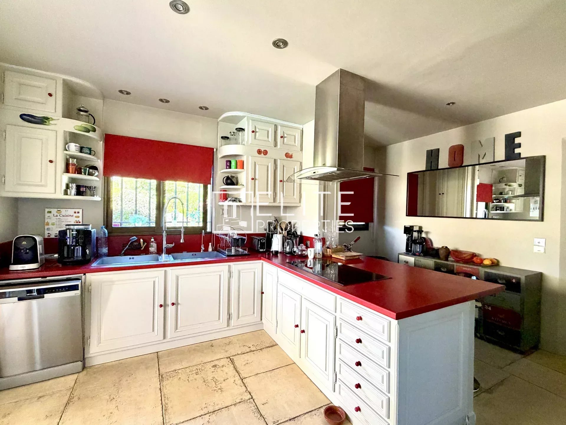 Kitchen of the villa in Mouans-Sartoux Modern kitchen with white furniture and red countertop in a family villa in Mouans-Sartoux.