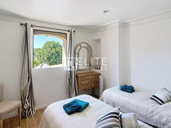 Room with two single beds and a window overlooking a garden.