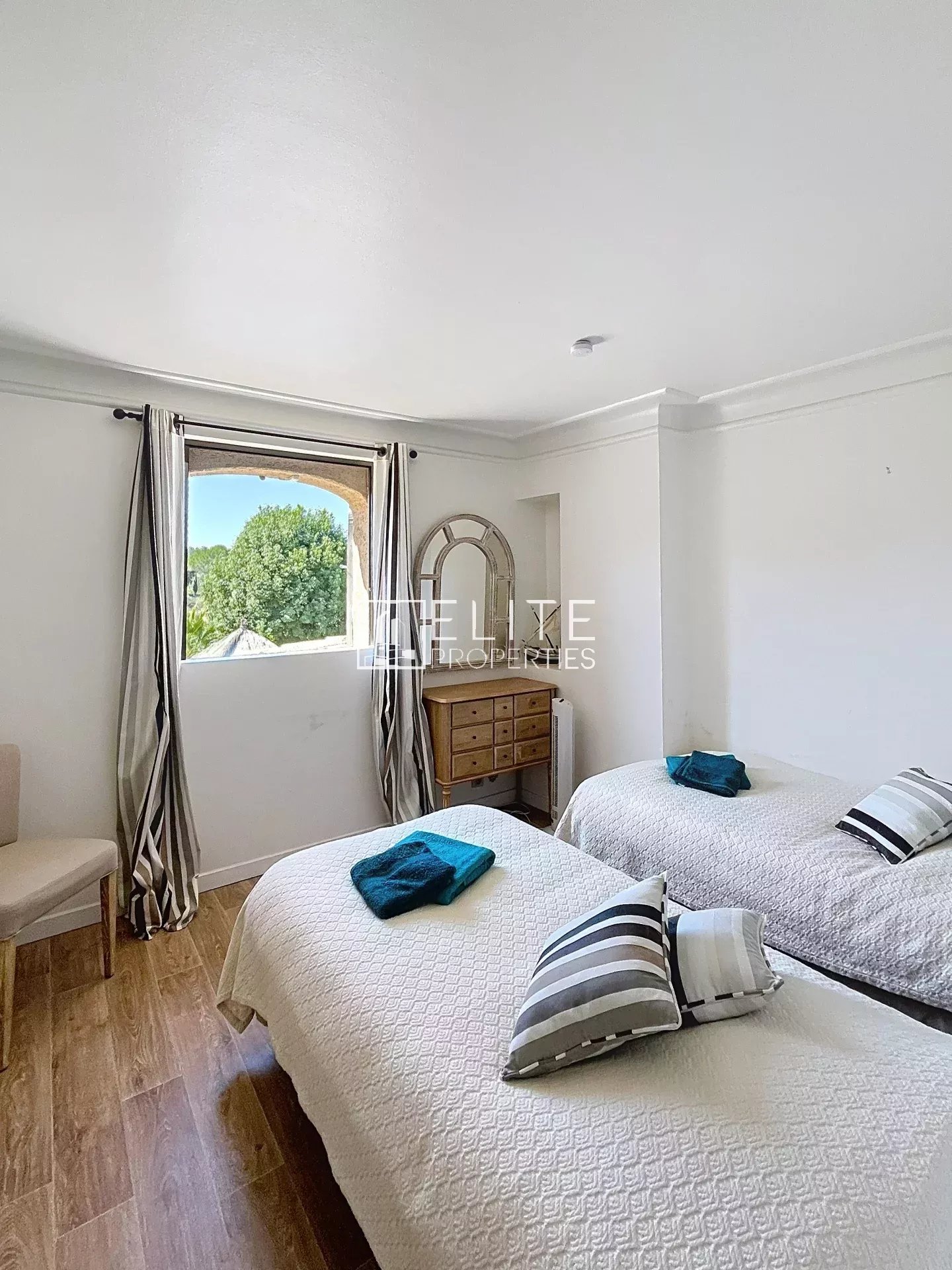 Room in the family property in Mouans-Sartoux Room with two single beds and a window overlooking a garden.