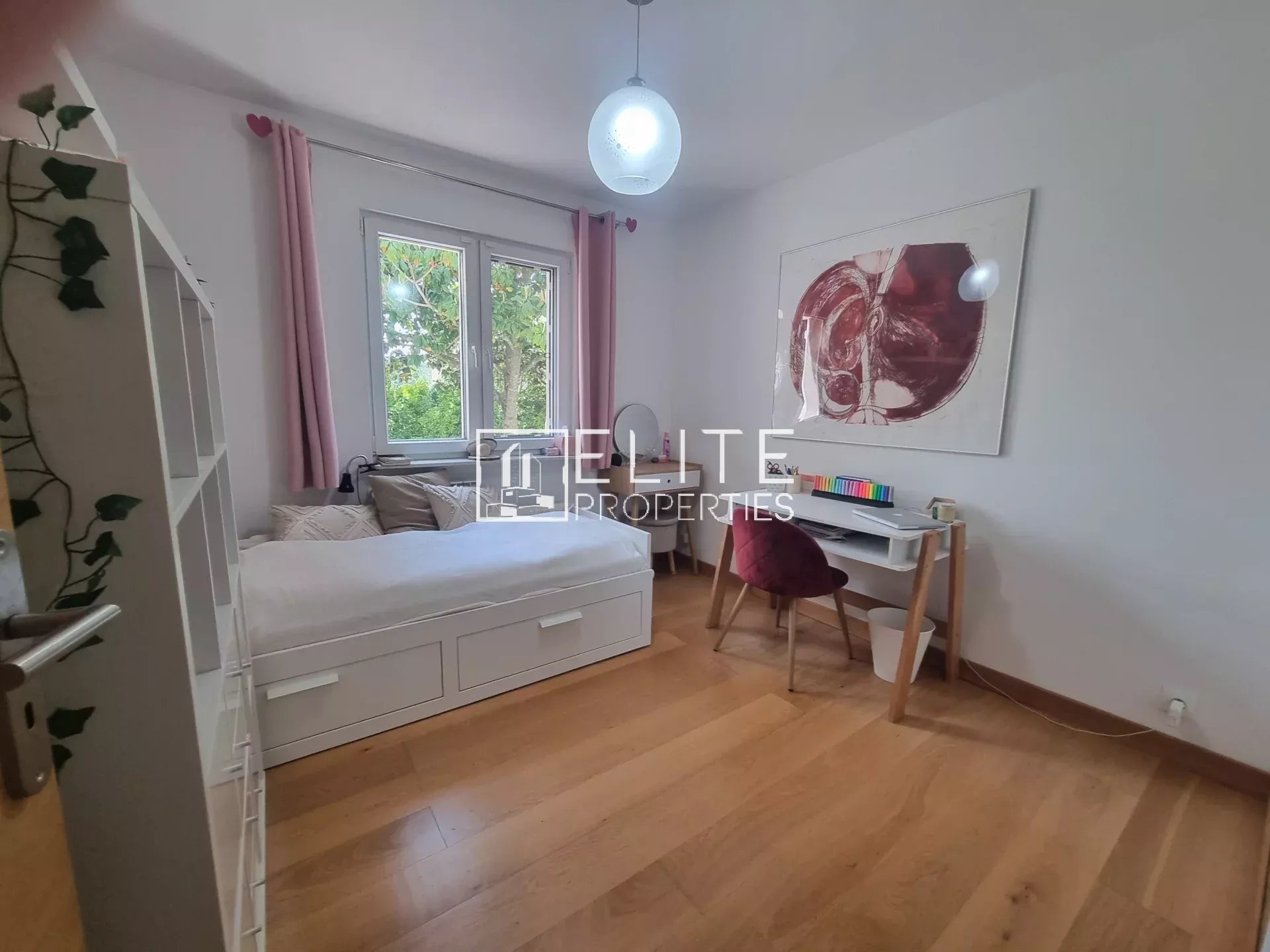 Chambre lumineuse avec lit et bureau dans une maison à vendre à Grasse.