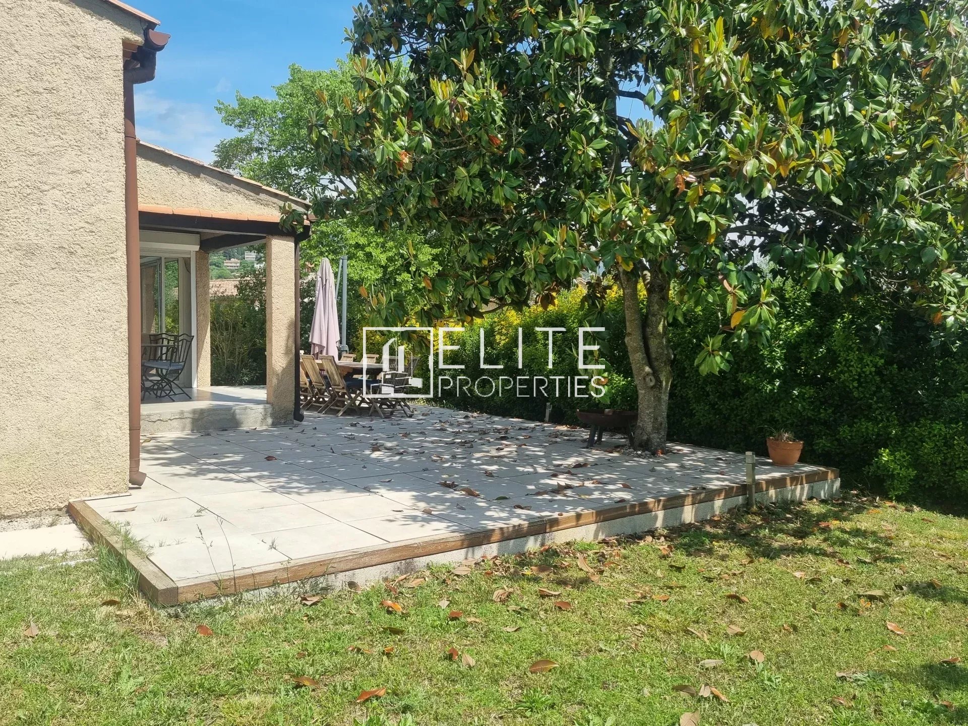 Terrasse ensoleillée avec jardin autour d'une maison de plain-pied à Grasse.