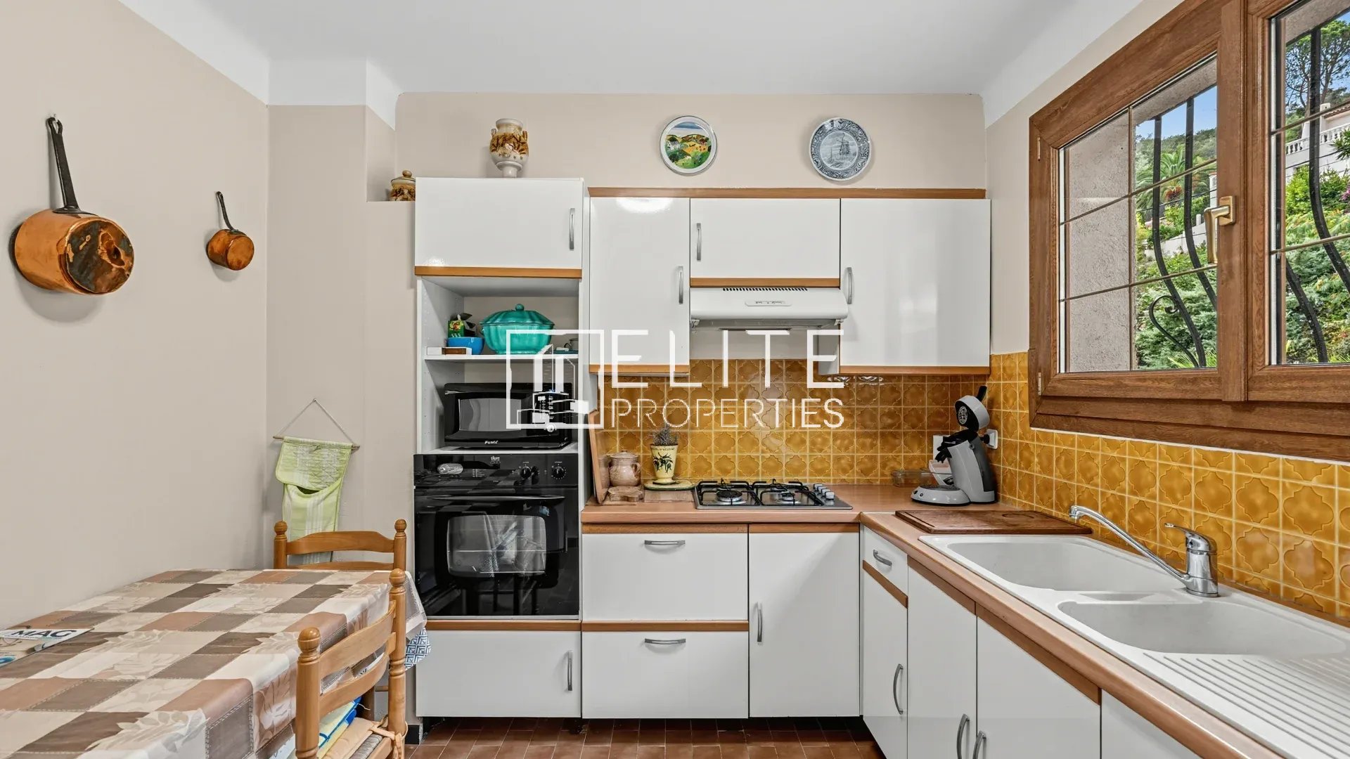 Cuisine à rénover à Mandelieu-la-Napoule Cuisine d'une maison à rénover à Mandelieu-la-Napoule, avec meubles blancs et carrelage jaune.