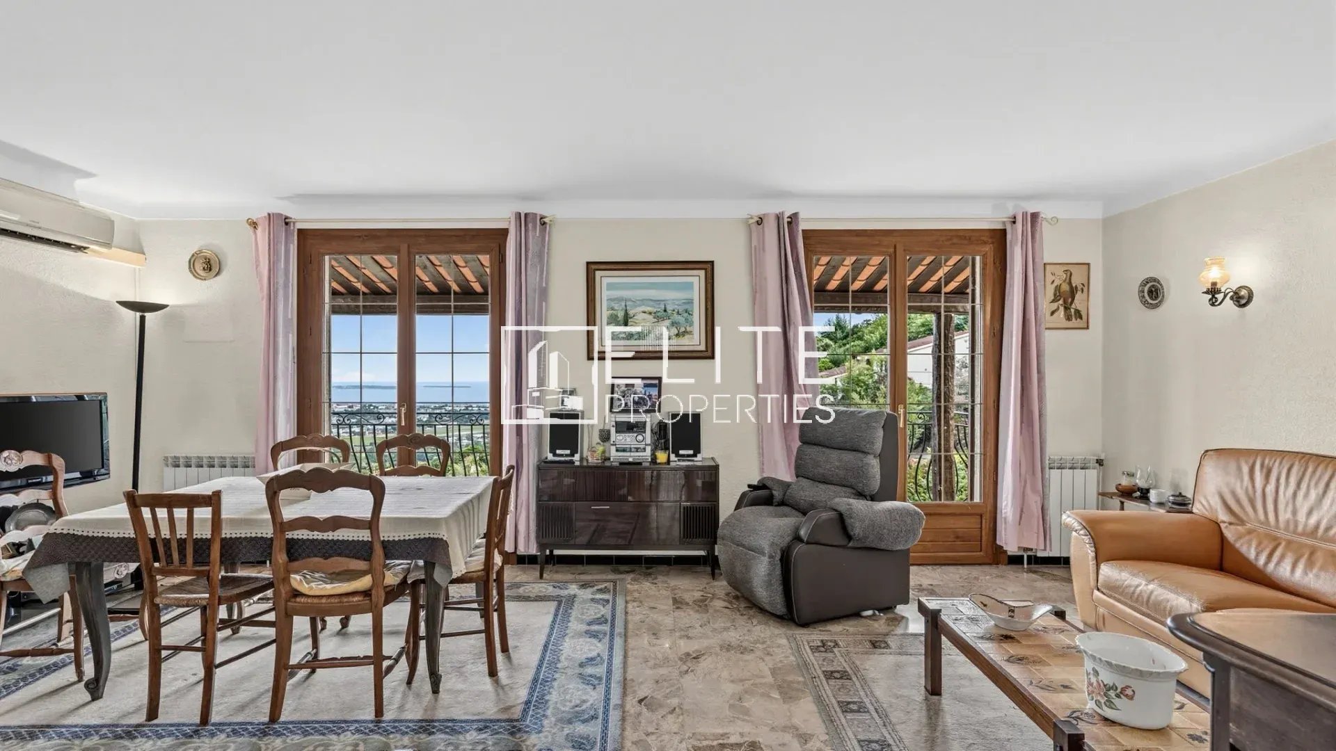 Intérieur d’une maison à rénover à Mandelieu-la-Napoule Intérieur d'une maison à rénover avec vue sur la mer, salon et salle à manger, mobilier varié.