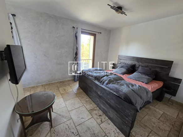 Chambre d'une maison à Saint-Vallier-de-Thiey avec lit double et balcon.