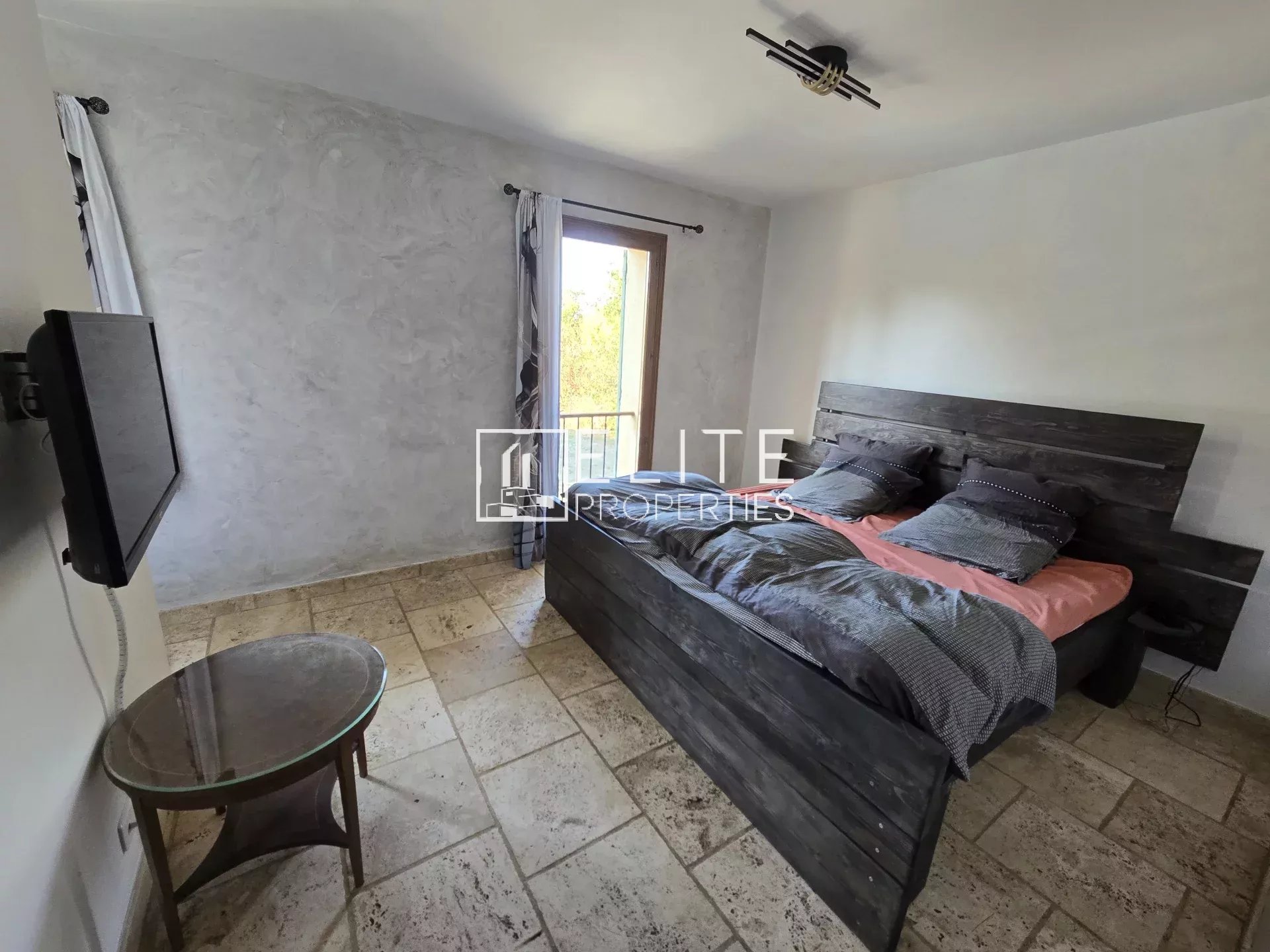 Chambre d'une maison à Saint-Vallier-de-Thiey avec lit double et balcon.