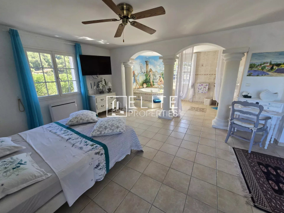 Intérieur d'une villa à Les Adrets-de-l'Estérel avec lit, décor lumineux et espace de vie ouvert.