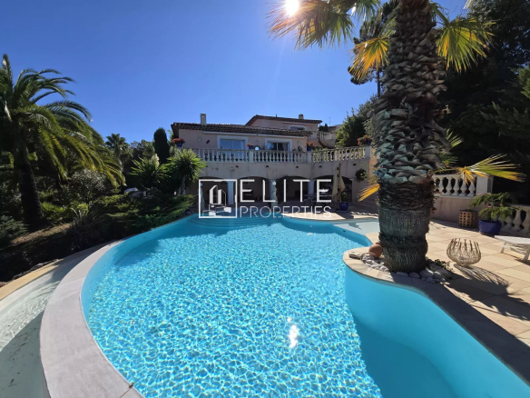 Piscine à débordement entourée de palmiers dans une villa à Les Adrets-de-l'Estérel.