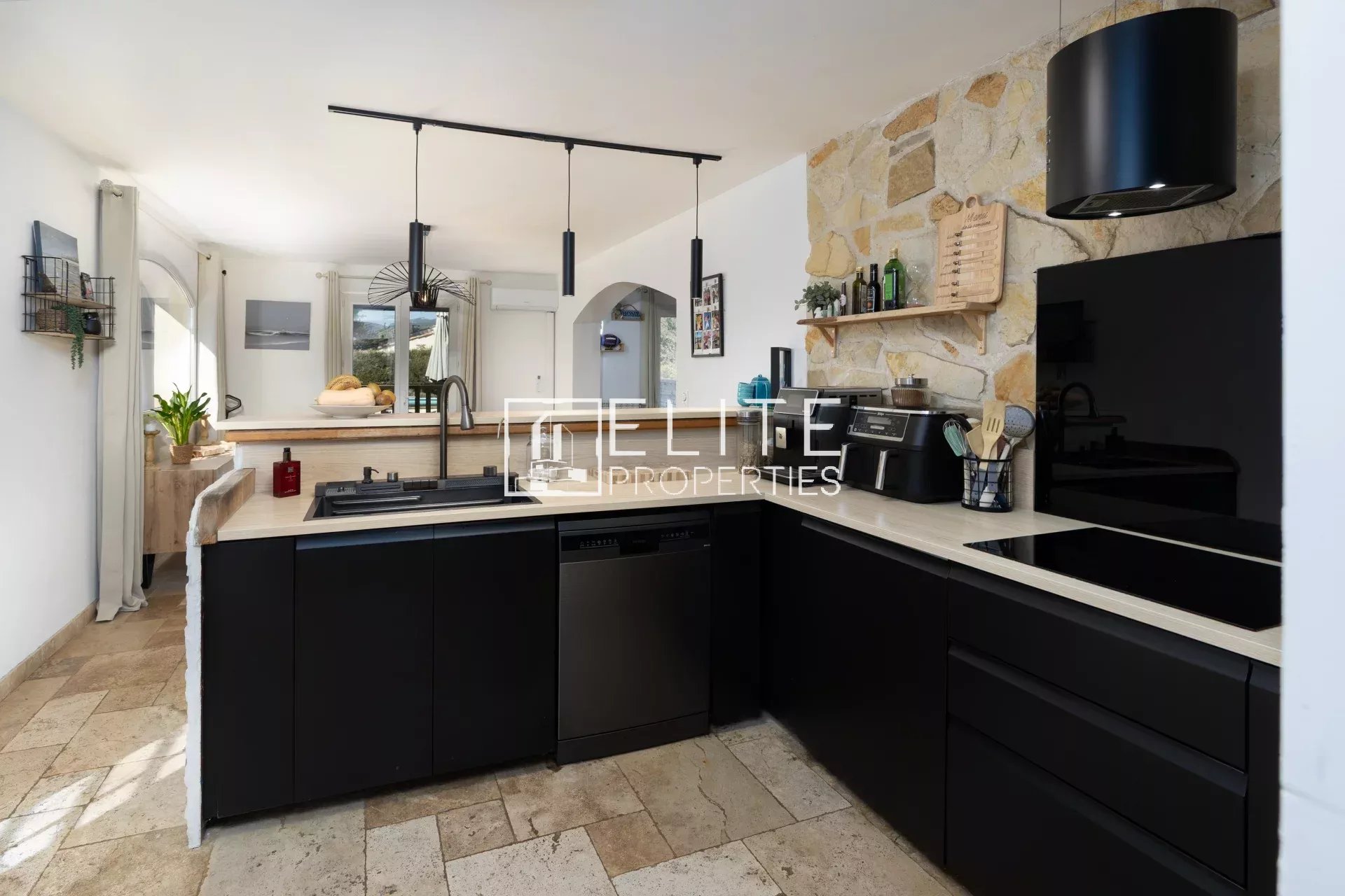 Cuisine de la villa à Fayence Cuisine moderne avec meubles noirs et plan de travail en pierre dans une villa à Fayence.