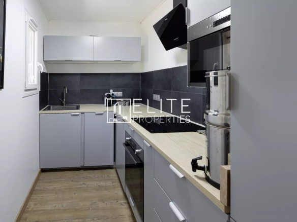 Cuisine moderne d'une villa à Fayence, avec meubles gris et plan de travail en bois.