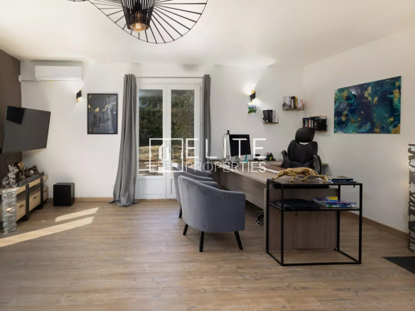 Intérieur d'un bureau moderne avec un fauteuil, un bureau et une télévision murale.