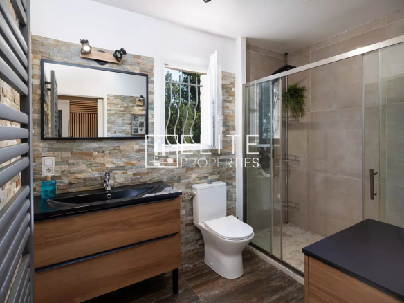 Salle de bain moderne avec douche, lavabo et toilettes.