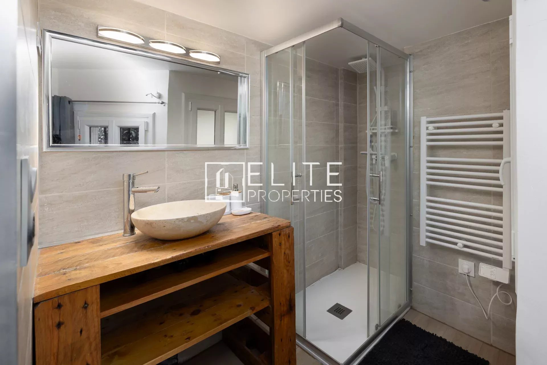 Salle de bain moderne Salle de bain moderne avec douche, lavabo en bois et miroir, décorée dans des tons neutres.