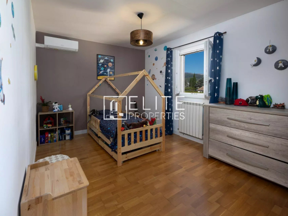 Chambre d'enfant dans une villa à Fayence avec lit en bois et décoration étoilée.
