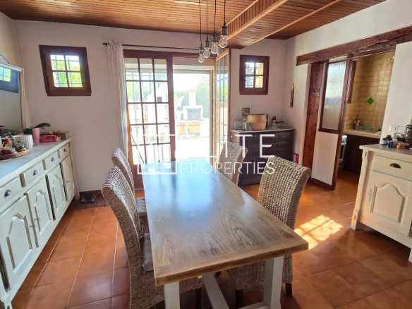 Intérieur d'une maison en pierre avec une salle à manger lumineuse et des meubles en bois.